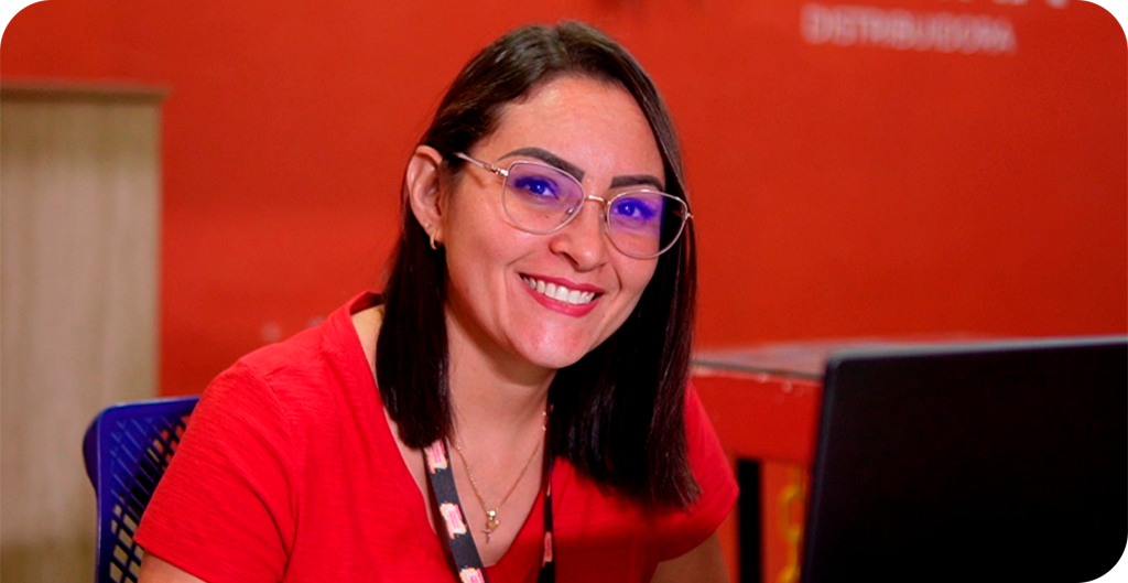 Atendente da Cheiro de Menina sorrindo em frente ao computador
